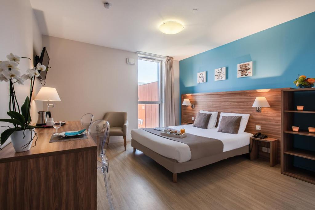 瓦讷瓦纳舒适城市公寓酒店的配有一张床和一张书桌的酒店客房