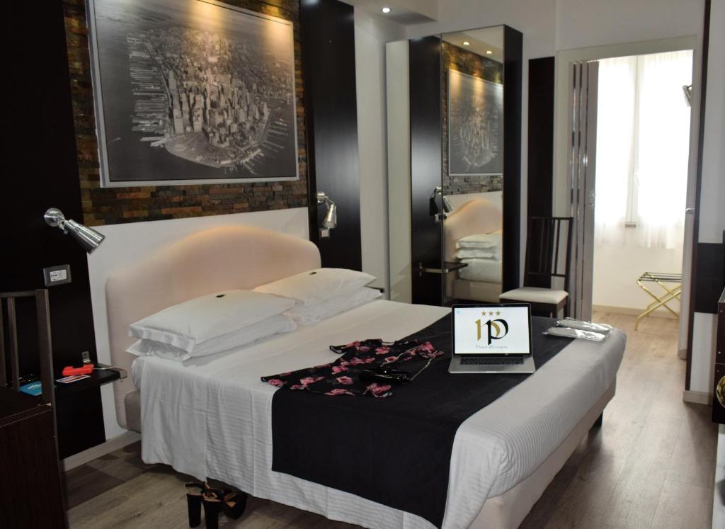 米兰佩鲁吉诺酒店的一间卧室配有一张带桌子和时钟的床