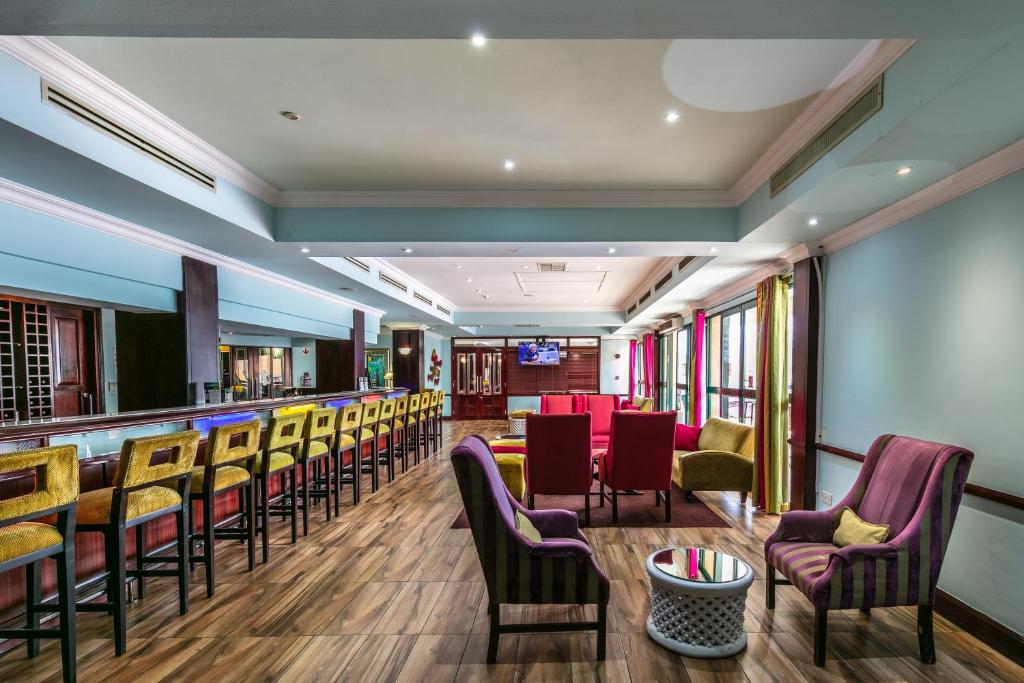 哈博罗内克雷斯塔总统酒店 的餐厅内的酒吧,配有桌椅