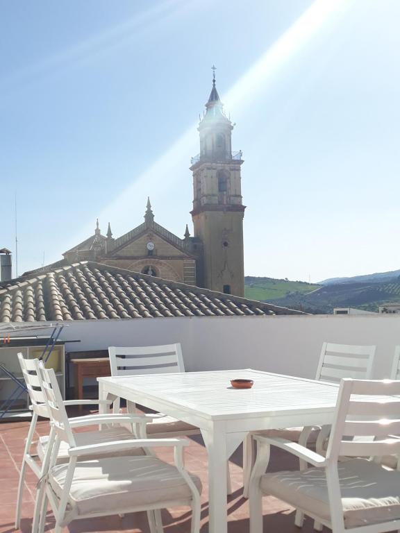 阿尔戈多纳莱斯ATICO-PLAZA的屋顶上的白色桌椅,钟楼