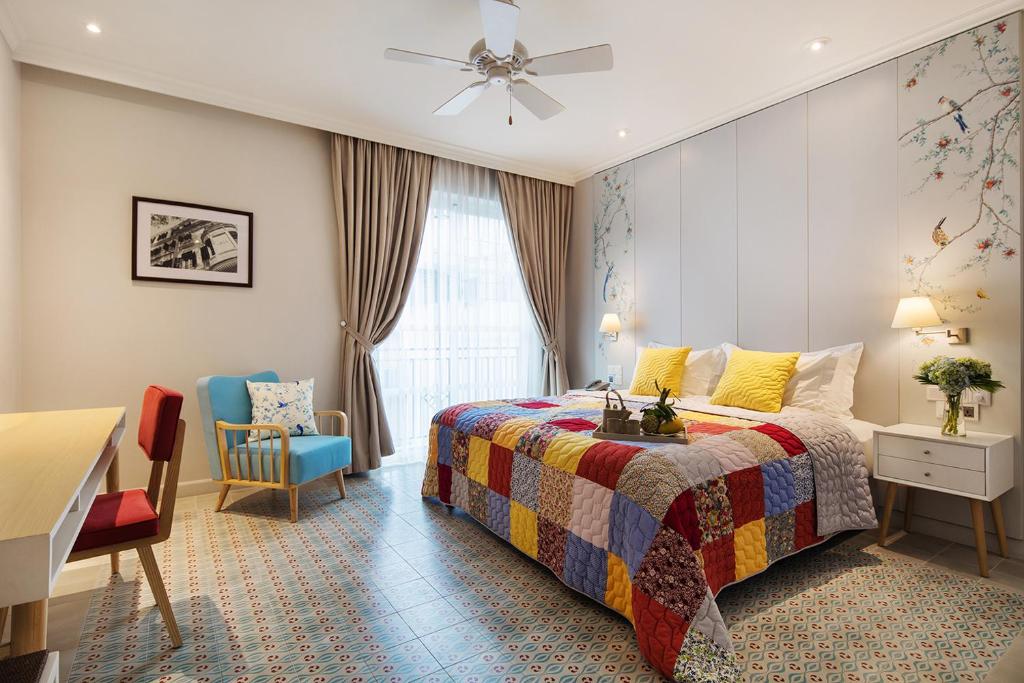 胡志明市梅森德卡米尔精品酒店的一间卧室配有一张床、一张书桌和一个窗户。
