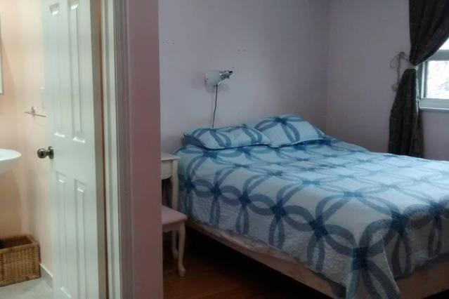 米西索加Private Room near Airport的一间卧室配有一张带蓝色床单的床和一扇窗户。