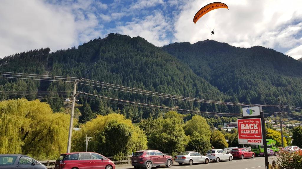 皇后镇Aspen Lodge Backpackers的滑翔伞在停车场上飞行