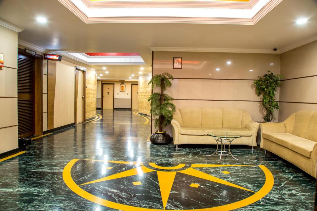 塞恩Hotel Tip Top Plaza的大堂配有沙发和地板上的标志