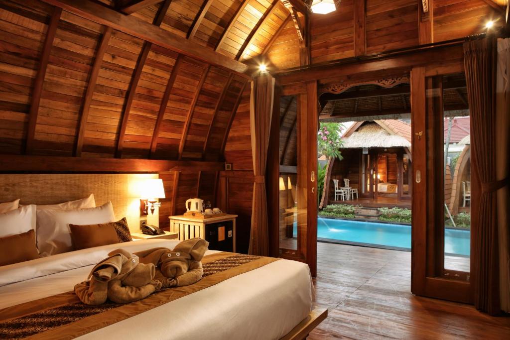 金巴兰Poedja Villa Jimbaran的一间带两张床铺的卧室,位于带游泳池的房间