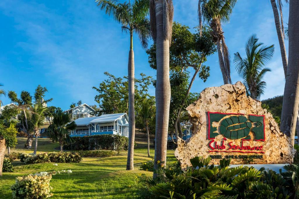 库莱布拉斯博奈俱乐部酒店的棕榈树前有标志的房子