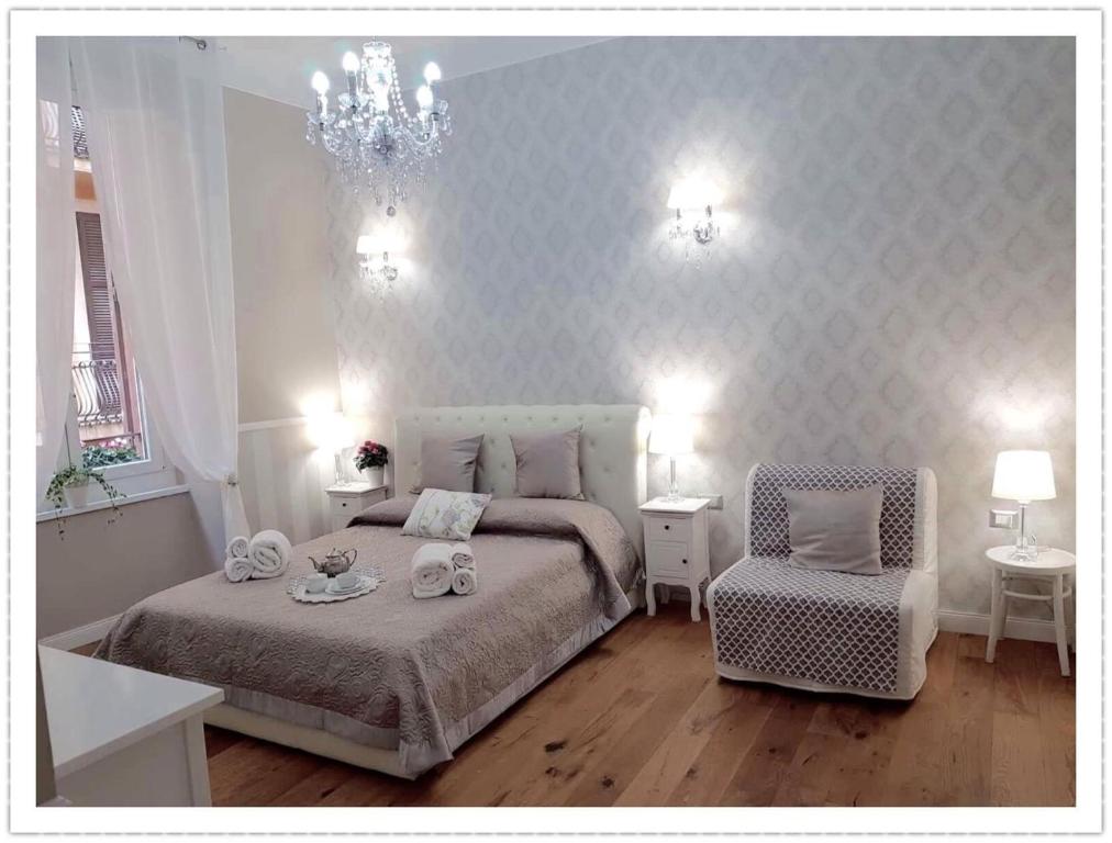 罗马Casa De Rose的一间卧室配有一张床、一把椅子和一个吊灯。