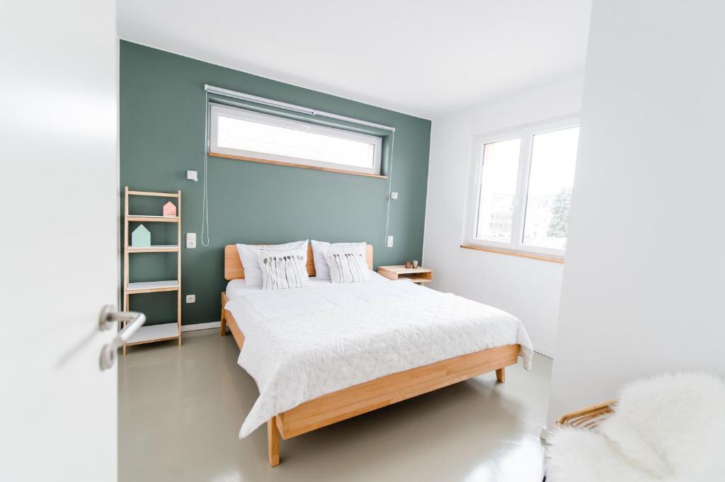 马格德堡ElbQuartier Apartments Magdeburg 'Die Stadtoase'的一间卧室配有一张蓝色墙壁的床