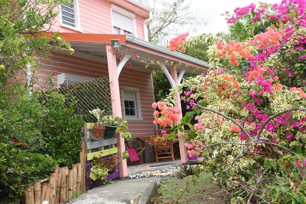 圣安娜Maison Corosole vue Mer的院子里的粉红色房子,鲜花盛开
