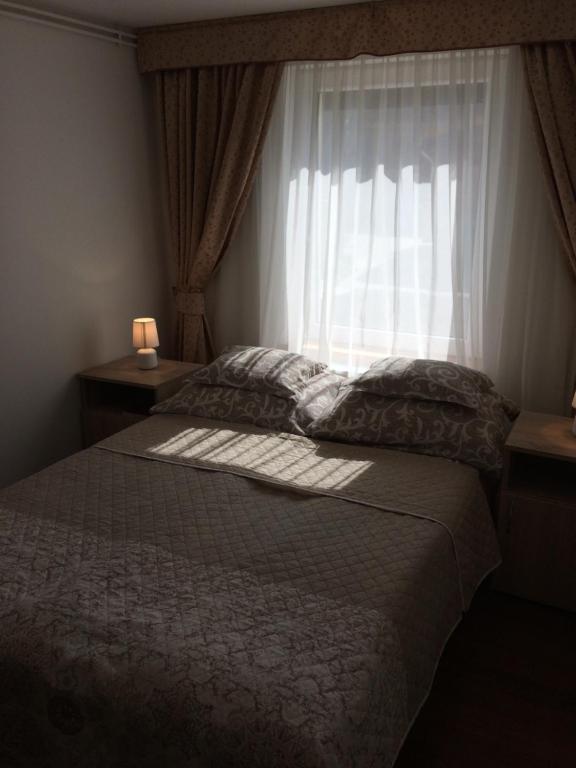 维谢格拉德Liliom Vendégház的一间卧室设有一张大床和窗户