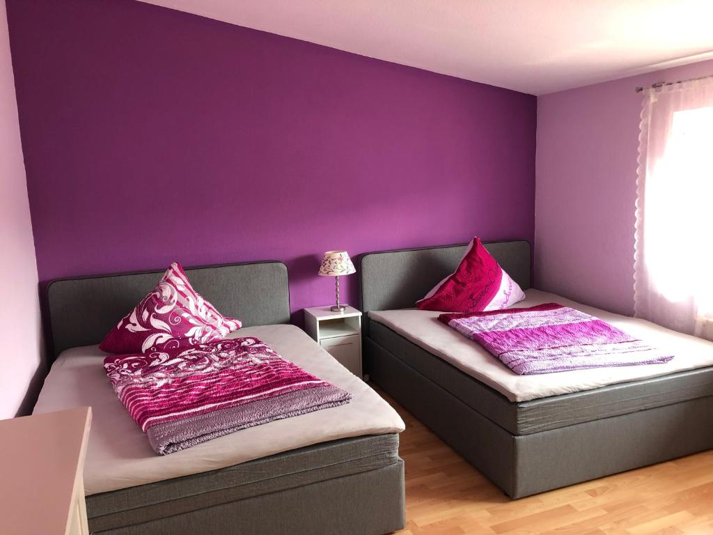 鲁斯特Apartment Country Europa-Park Ticket Garantie的紫色墙壁客房的两张床