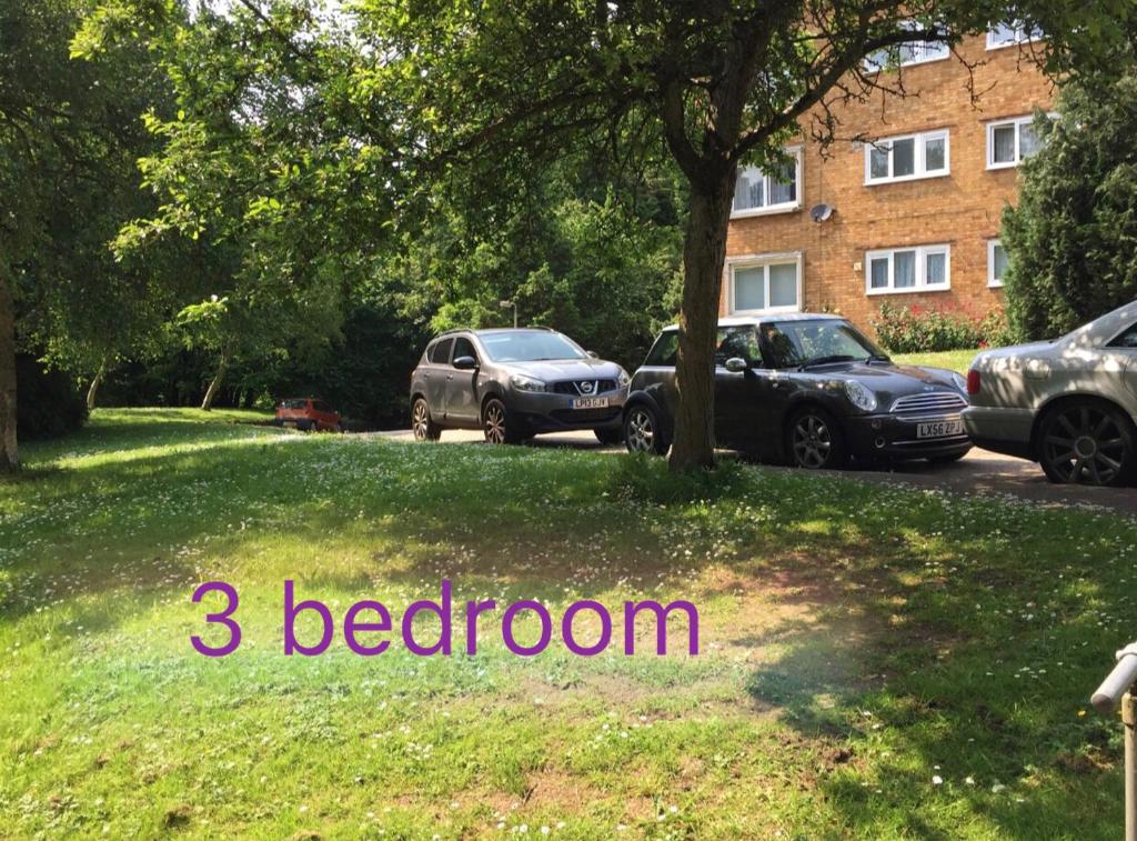 圣奥尔本斯Spacious 3 Bedroom Apartment的两辆汽车停在一个院子,卧室里写字