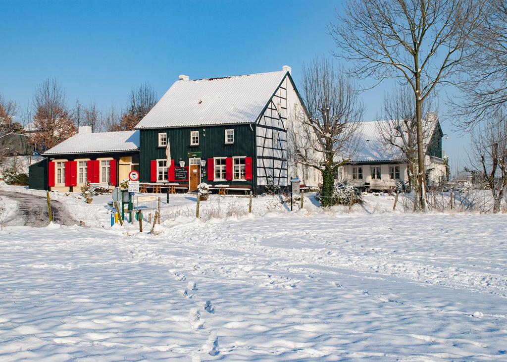 埃彭Hotel,Herberg & Appartementen de Smidse的雪中的一个黑色和红色的大谷仓