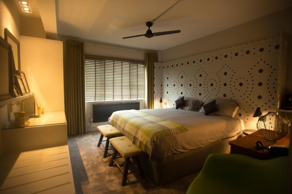查塔姆St George Hotel Rochester-Chatham的一间卧室配有一张床、一张书桌和一个窗户。