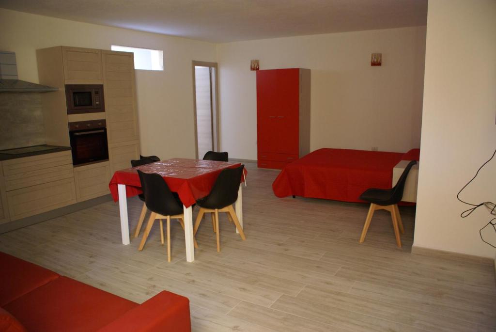 卡拉古诺内casa mariolu 2的一间用餐室,配有红色的桌子和椅子