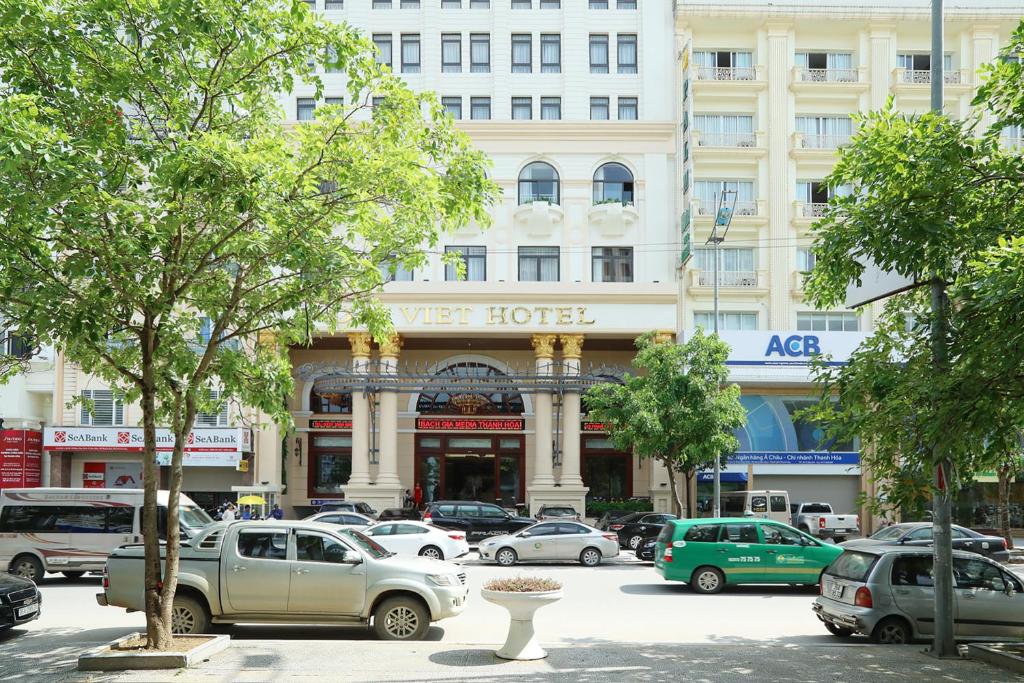 清化Dai Viet Hotel的一条街道上,汽车停在酒店门前