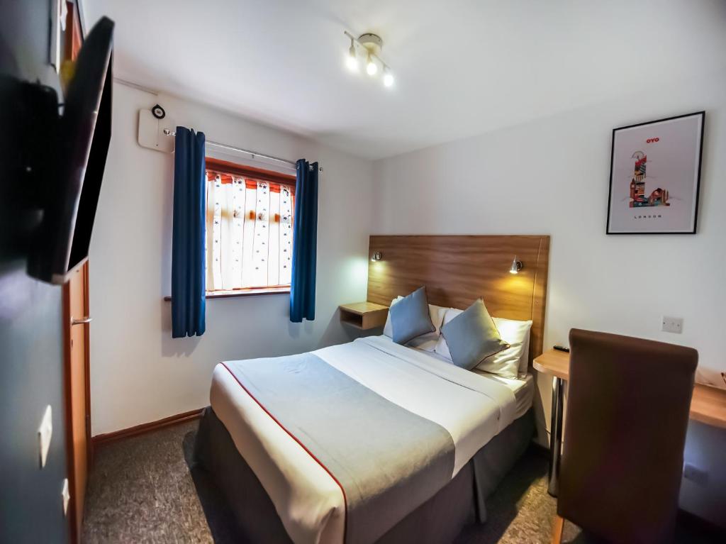 依尔福Arinza Hotel, London Ilford的配有一张床和一张书桌的酒店客房