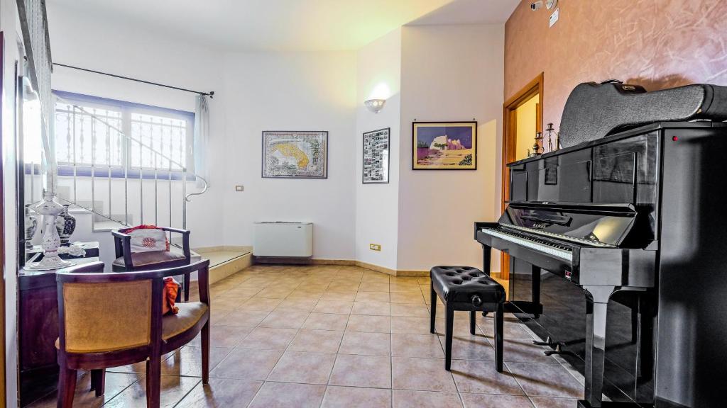 卡斯特里尼亚诺德尔卡波Casa Del Sole Relax Room的客厅配有钢琴和桌子