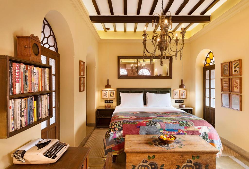 加尔各答Calcutta Bungalow的一间卧室配有一张床、一张书桌和一个键盘