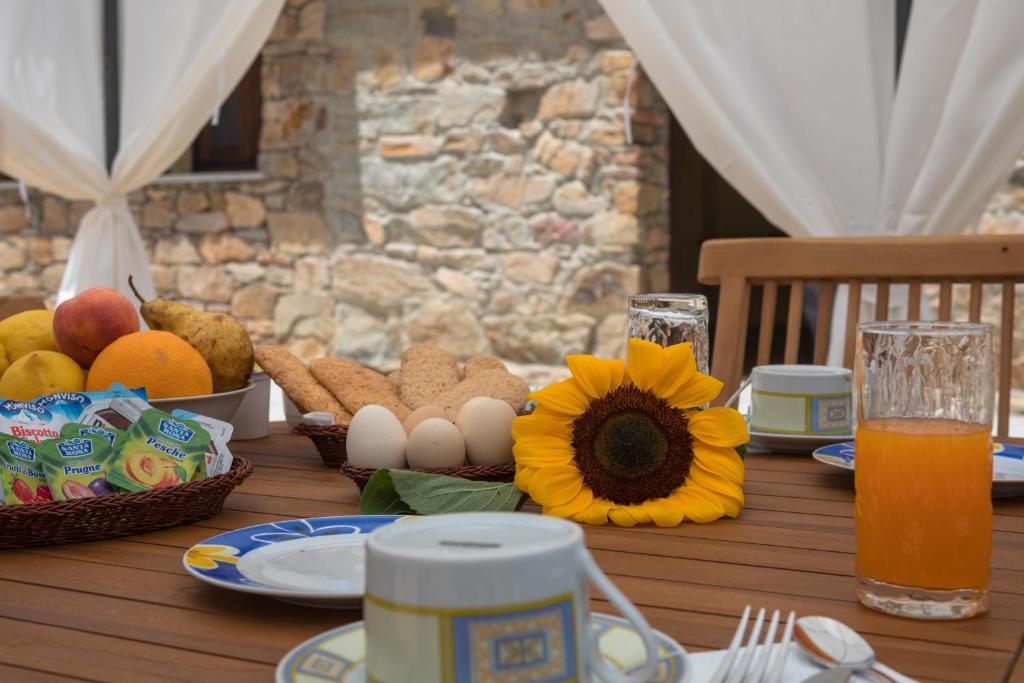 阿尔布斯Arroccas de is Istellas的一张木桌,早餐包括鸡蛋和水果