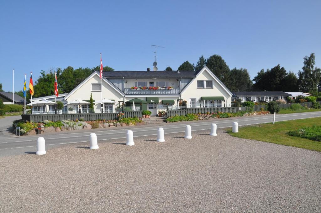 Tappernøje弗基德克罗恩酒店的路边有白色柱子的建筑物