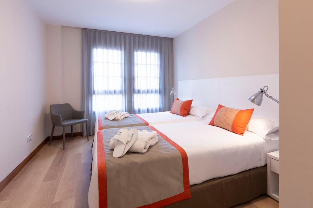 萨拉戈萨罗斯杰拉索勒斯公寓的酒店客房,配有两张带毛巾的床