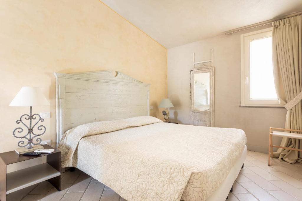 特雷斯努拉吉斯Il Cortiletto Hotel Maison的卧室设有一张白色大床和一扇窗户。