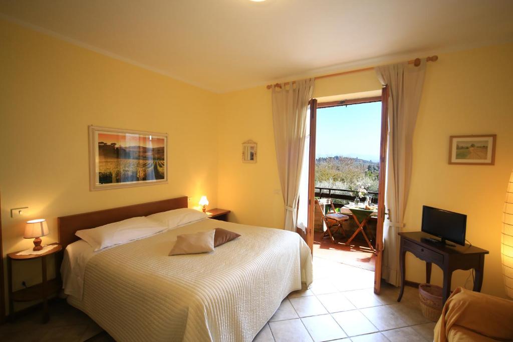 圣吉米纳诺Casa Milena的一间卧室配有一张床、一台电视和一个阳台