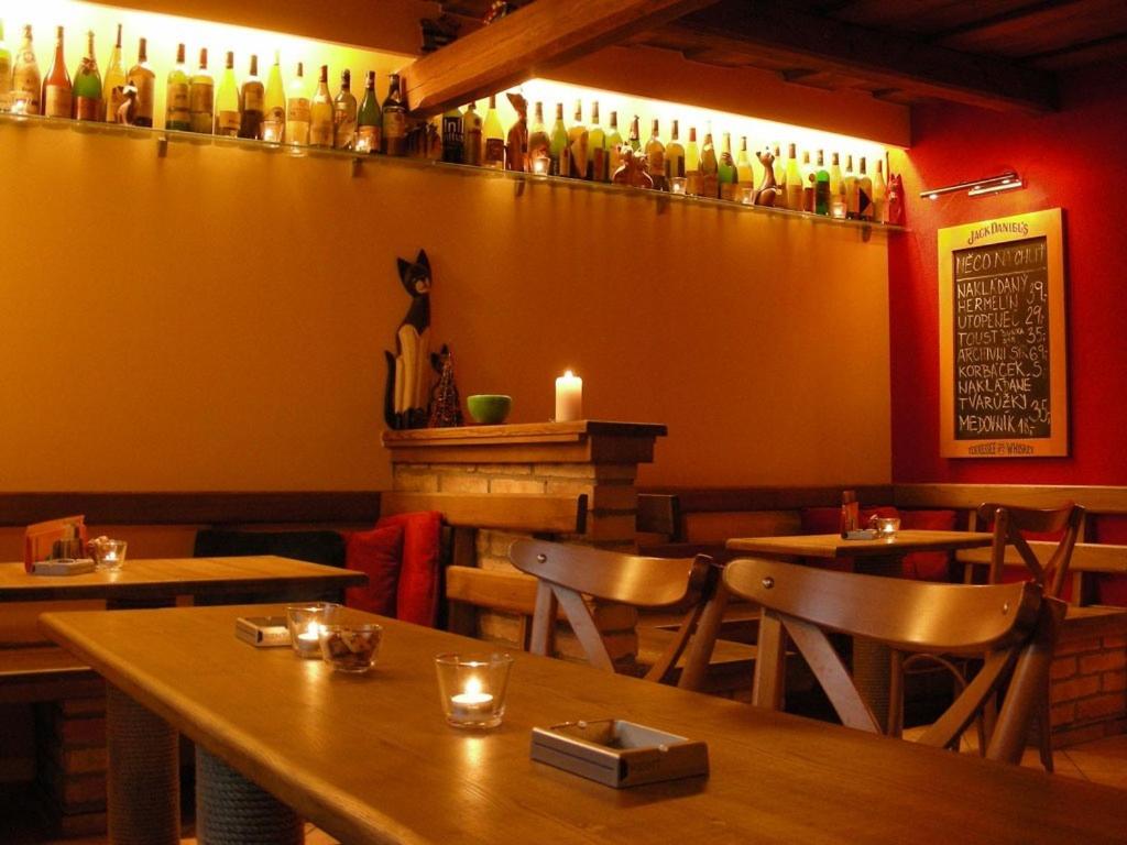 穆捷尼采悠柯基膳食公寓的餐厅墙上设有桌椅和瓶子