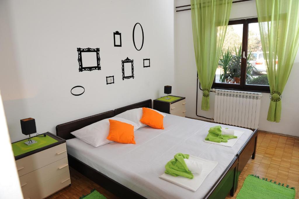 普洛切Ljubica Comfortable Apartment的一间卧室配有带橙色和绿色枕头的床