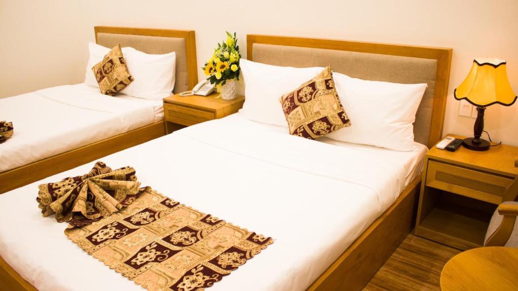 波来古市Hoài Thương Hotel的酒店客房,设有两张床和一张鲜花桌。