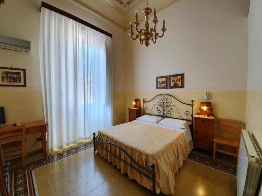 巴勒莫凯沃尔酒店的一间卧室配有一张床和一个吊灯