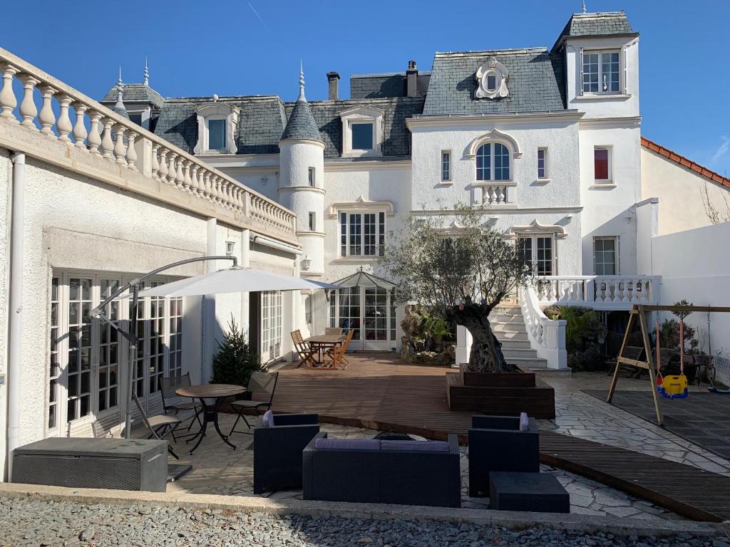 讷伊-普莱桑斯Villa Florian的房屋设有带桌椅的庭院