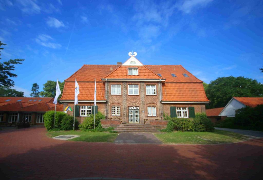 奥特尔恩多夫Jugendherberge Otterndorf的一座带橙色屋顶的大型砖屋