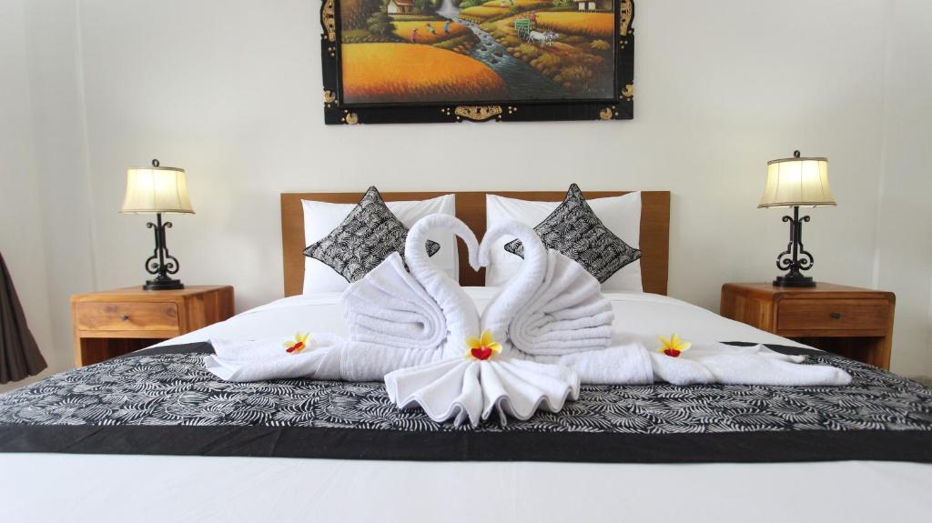 乌布Pondok Serayu的两个天鹅坐在床上,带毛巾