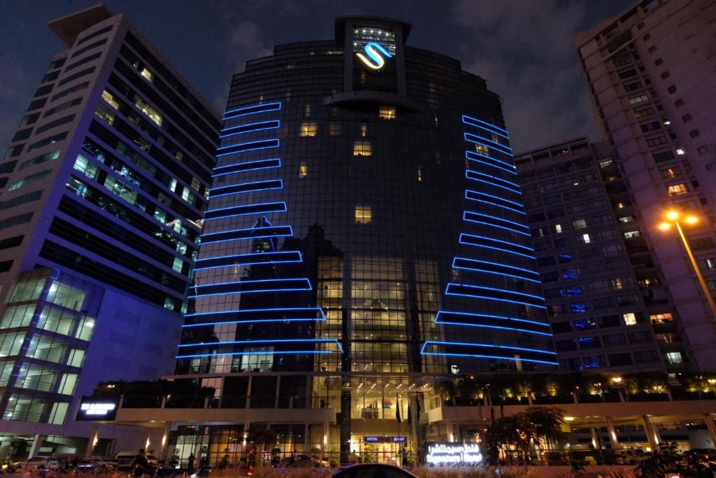 迪拜Signature 1 Hotel Tecom的一座高大的建筑,上面有钟