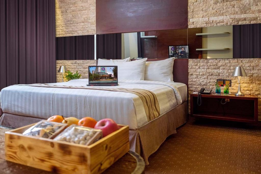 名古屋维也纳精品酒店的酒店客房,配有一张带笔记本电脑的床