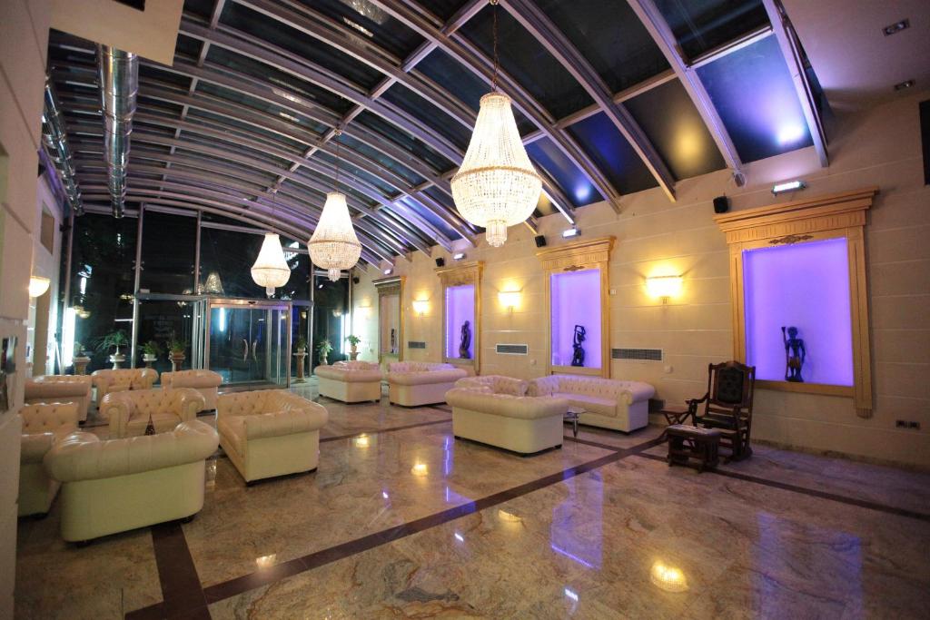 伊古迈尼察阿斯托里亚酒店的大型客房配有白色沙发和吊灯。