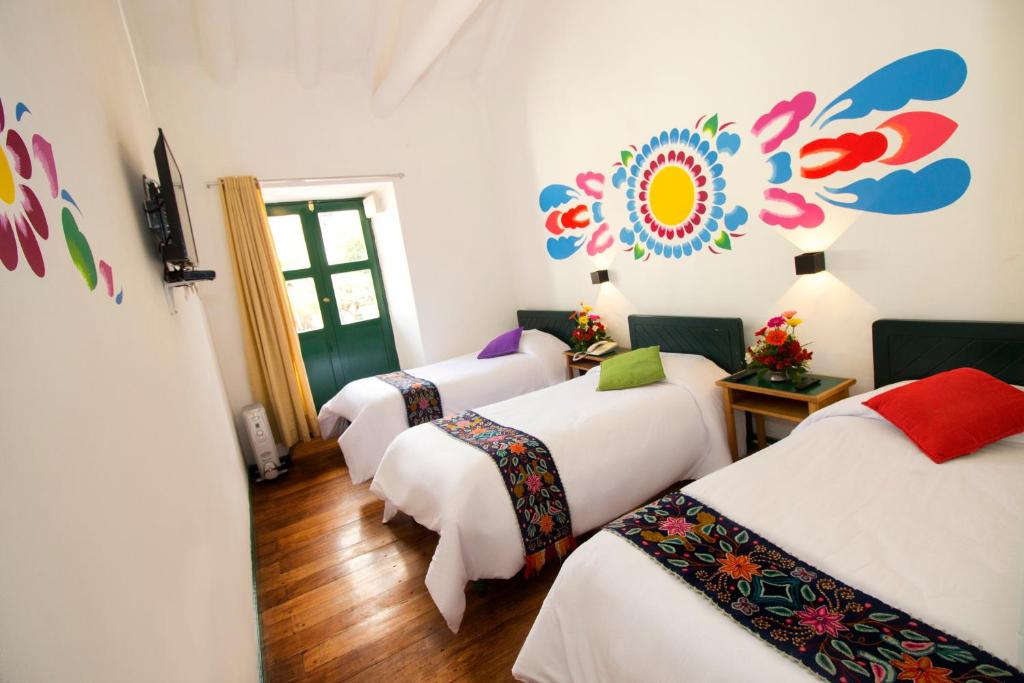 库斯科Cusco Plaza Nazarenas的一间客房内的四张床