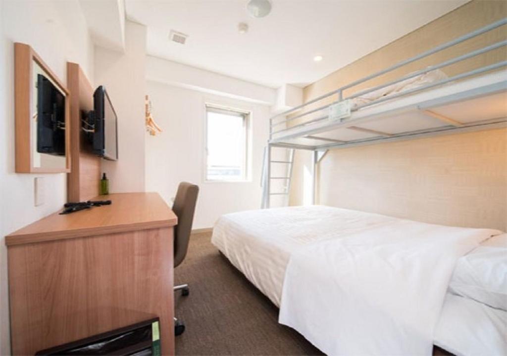 磐城Iwaki - Hotel / Vacation STAY 22988的一间酒店客房,配有一张床和一台电视