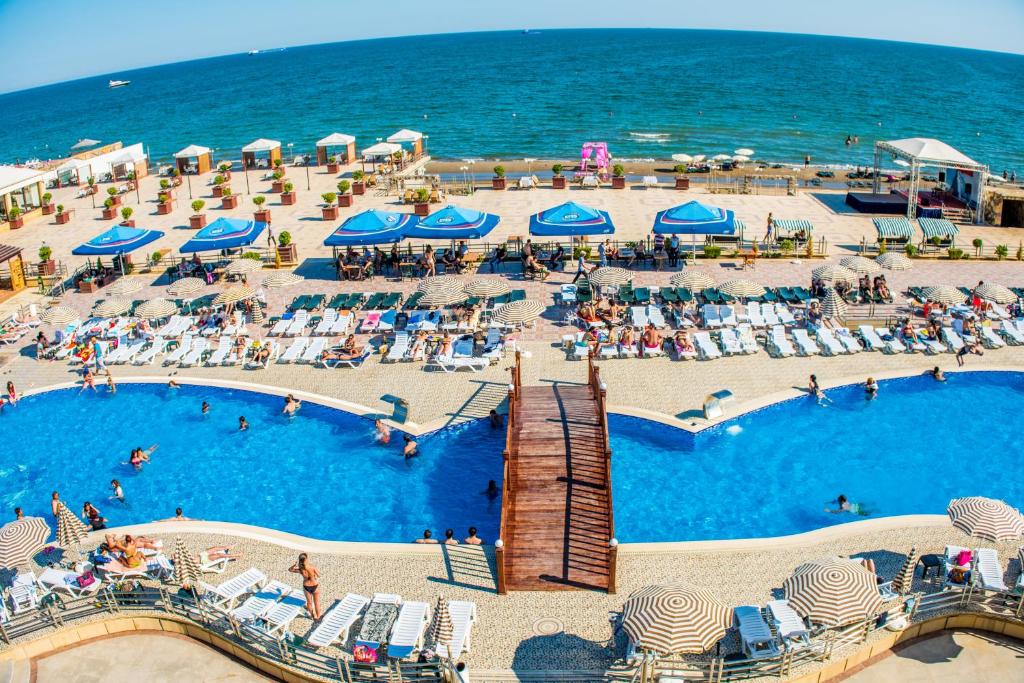 巴库阿伊斯博度假酒店的享有带椅子和遮阳伞的游泳池的上方景致