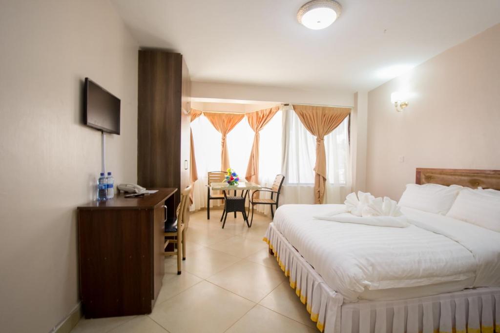 ThikaPaleo Hotel and Spa的一间卧室配有一张床、一张桌子和一张桌子