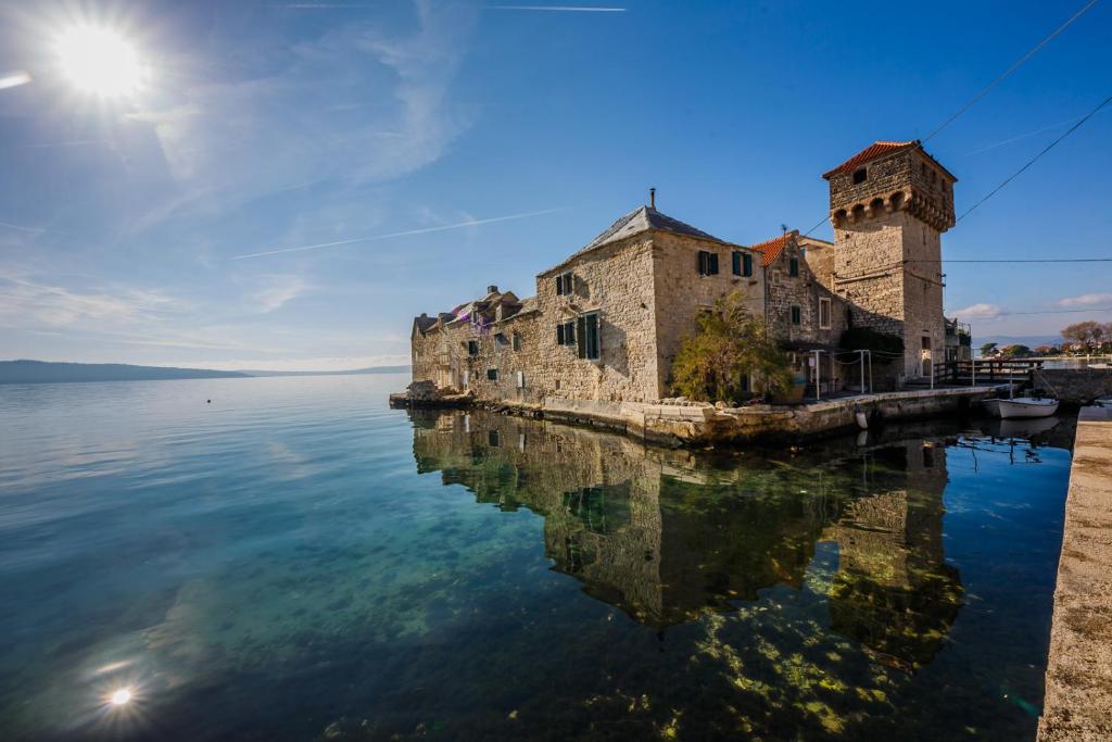 卡什泰拉Water Castle House的水面上的一座旧建筑,倒影