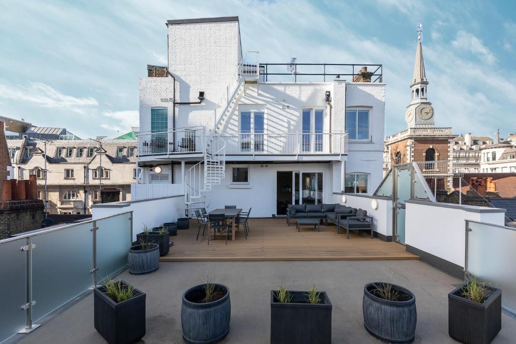 伦敦ALTIDO Luxury 2 bed flats with terraces near Piccadilly Circus的阳台种植了盆栽植物,拥有白色的房子
