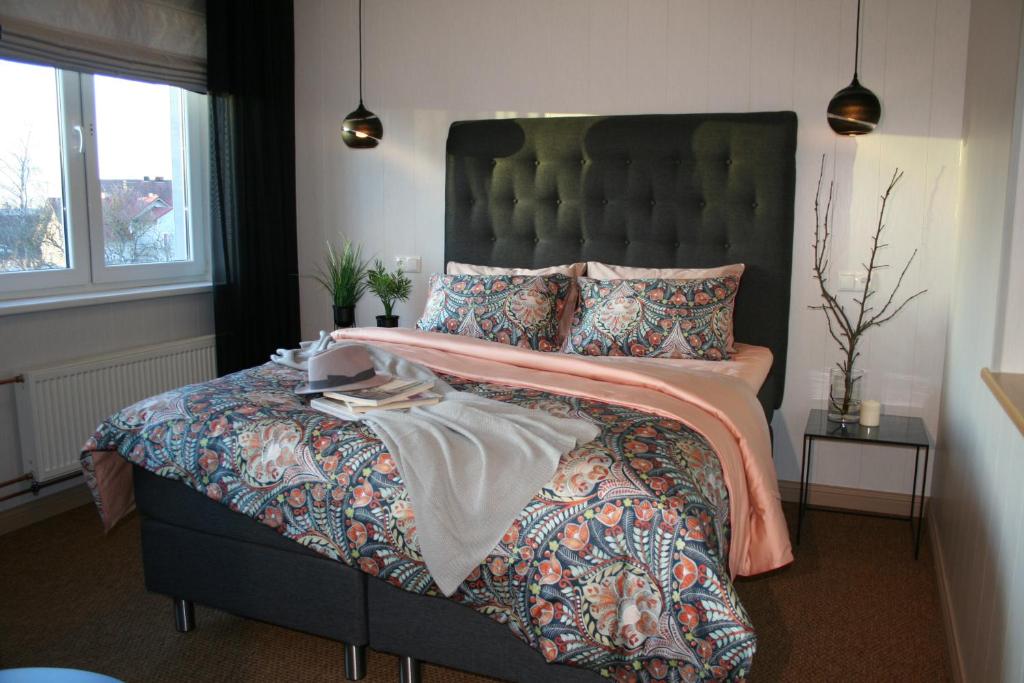 派尔努Sadama street Villa的一间卧室配有一张大床和绿色床头板