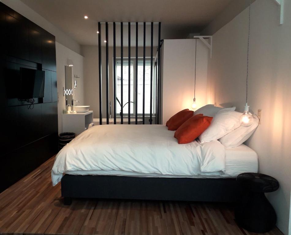 科特赖克B&B Ar'Home的一间卧室配有带白色床单和红色枕头的床。