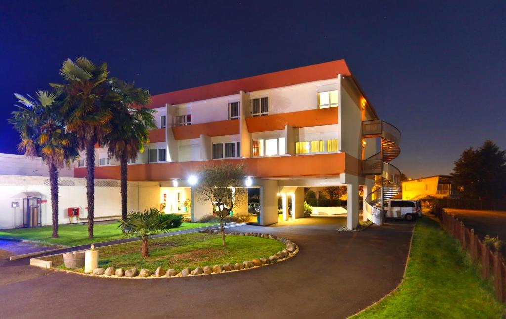 波城Cit'Hotel Atlantic Hotel的一座棕榈树环绕的大建筑