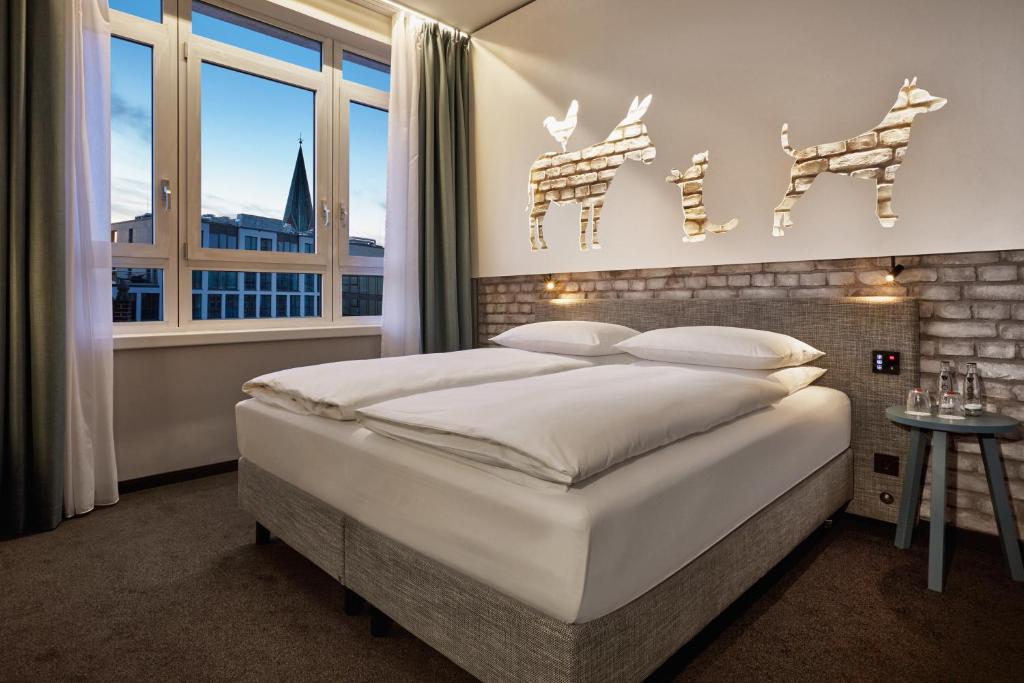 不莱梅不来梅H5+酒店的卧室设有一张白色大床和一扇窗户。