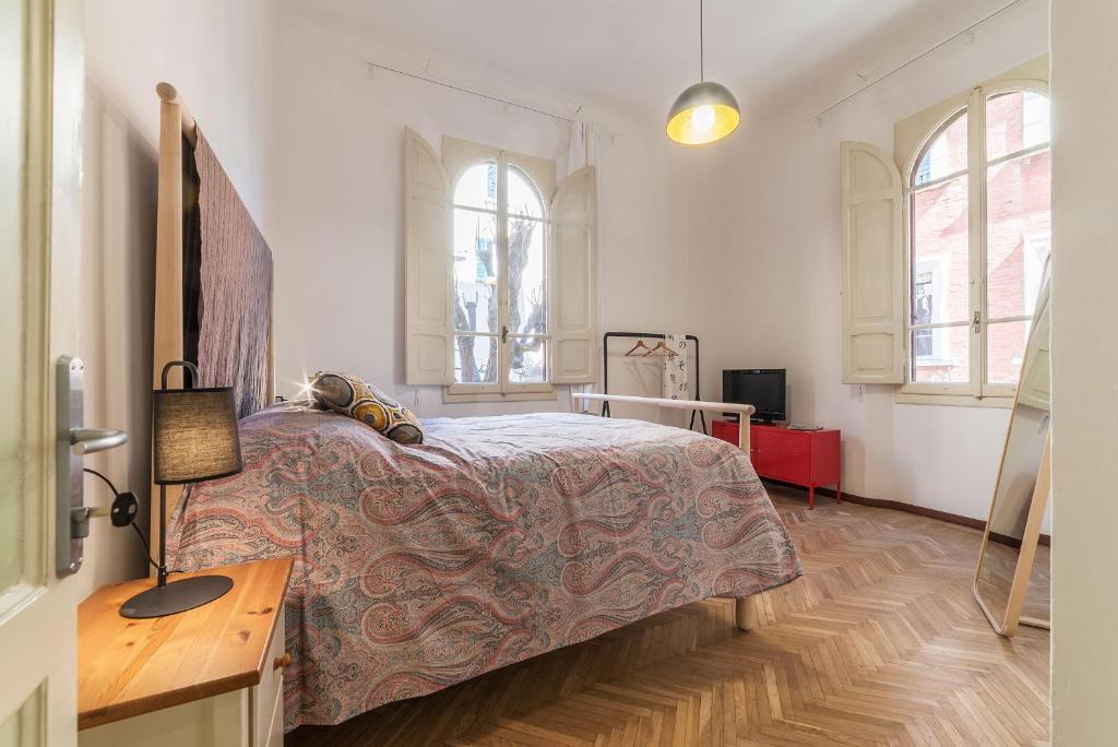 博洛尼亚Tilia的一间卧室配有一张床、一张书桌和两个窗户。