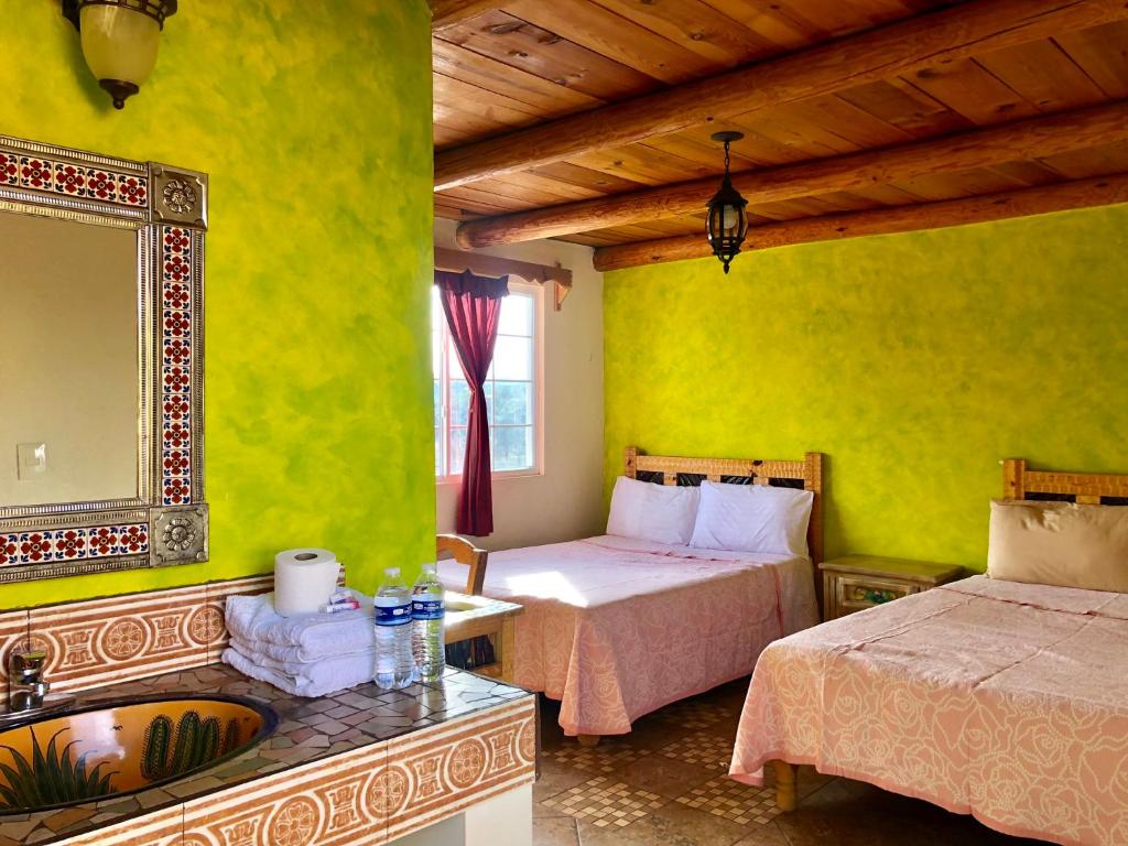 Mesa ColoradaHotel JADE的一间卧室设有两张床、镜子和水槽
